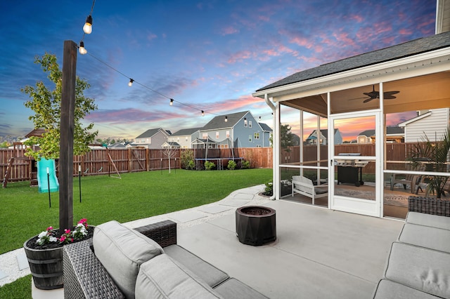 204 Honey Horn Dr, Summerville, SC 29486 - patio terrace at dusk with a trampoline, a fenced backyard, ceiling fan, a sunroom, and a lawn