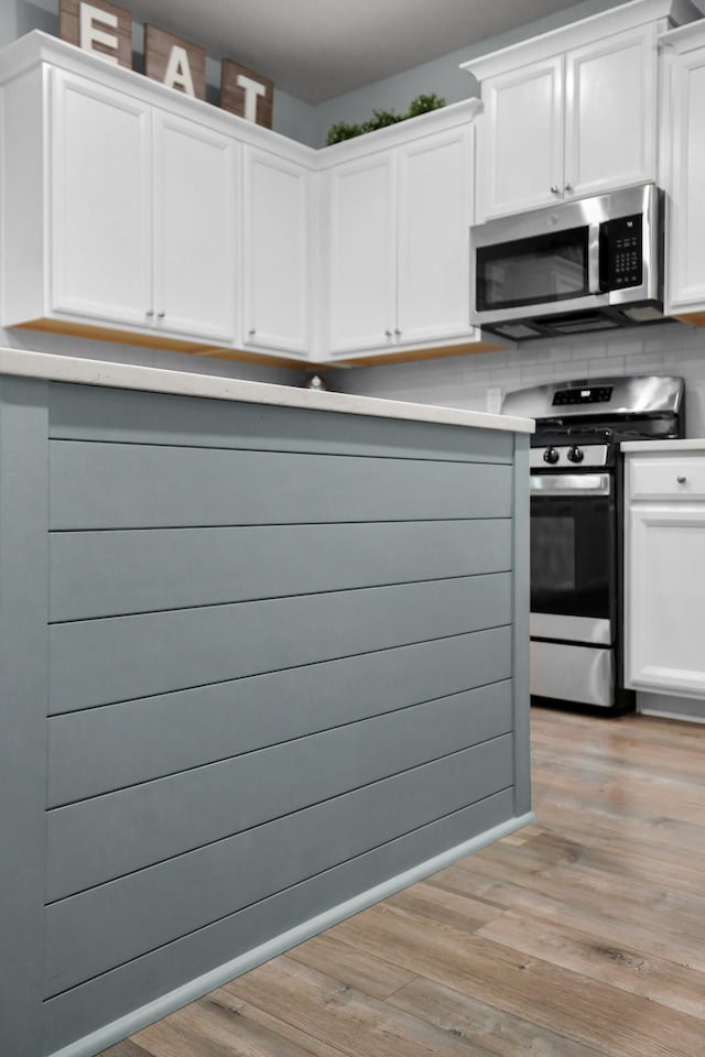 204 Honey Horn Dr, Summerville, SC 29486 - kitchen featuring light wood finished floors, white cabinetry, backsplash, and appliances with stainless steel finishes