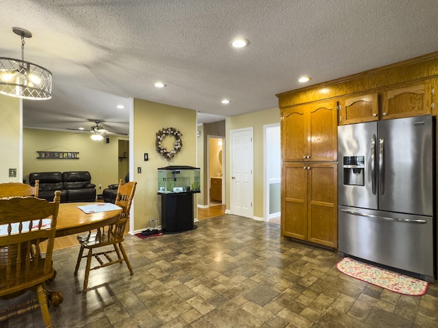 5505 Indigo Makers Trce, Charleston, SC 29418 - kitchen with stone tile floors, baseboards, brown cabinets, stainless steel fridge with ice dispenser, and a ceiling fan