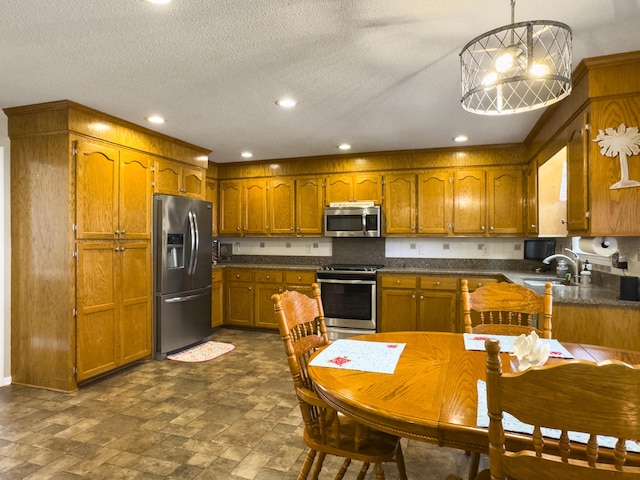 5505 Indigo Makers Trce, Charleston, SC 29418 - kitchen featuring brown cabinetry, appliances with stainless steel finishes, dark countertops, a sink, and recessed lighting