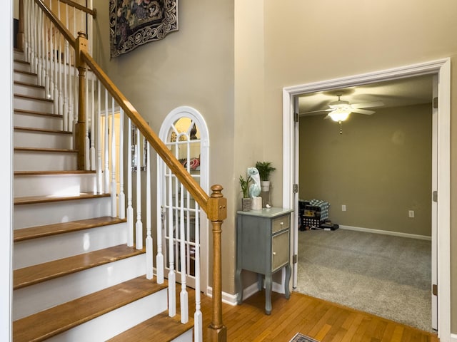5505 Indigo Makers Trce, Charleston, SC 29418 - stairway featuring baseboards, ceiling fan, hardwood / wood-style flooring, and a high ceiling