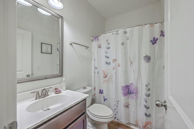 bathroom with vanity, a shower with shower curtain, and toilet