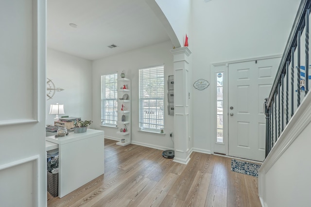 entrance foyer with light wood-type flooring and decorative columns