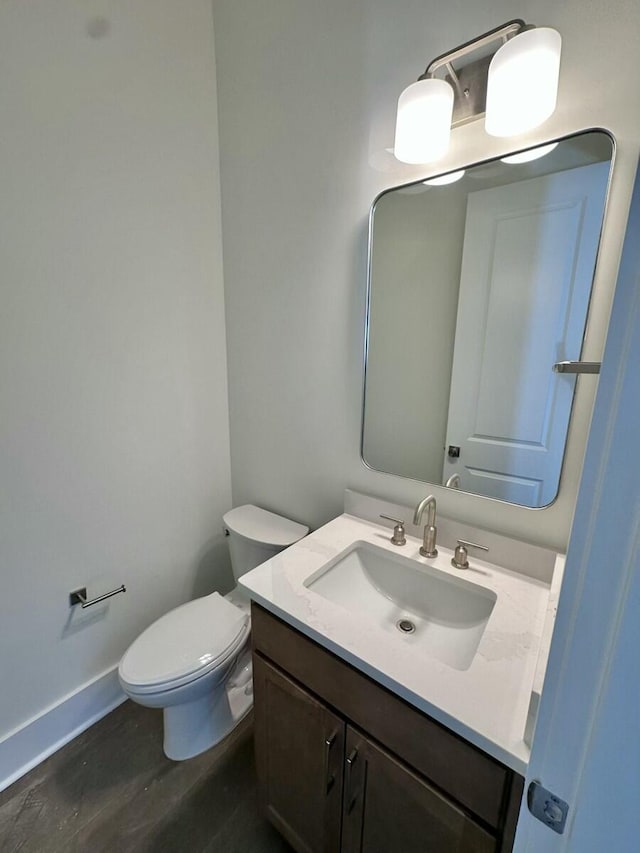 bathroom featuring vanity, wood-type flooring, and toilet