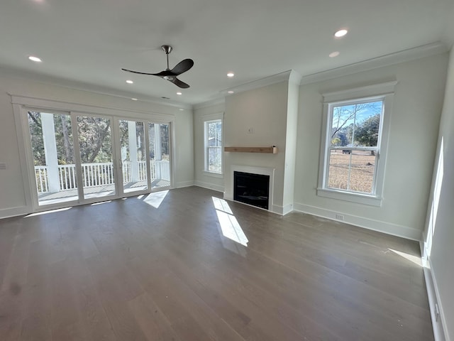 unfurnished living room with crown molding, a wealth of natural light, ceiling fan, and hardwood / wood-style flooring