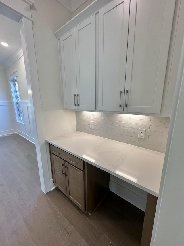 interior space with tasteful backsplash, light stone counters, white cabinetry, and light wood-type flooring