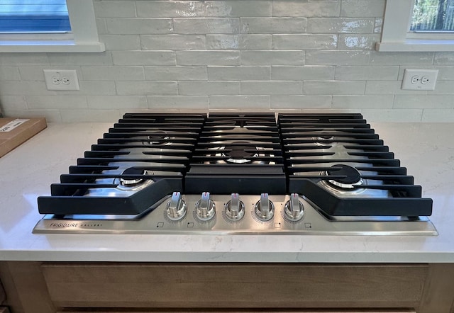 interior details featuring decorative backsplash and stainless steel gas cooktop