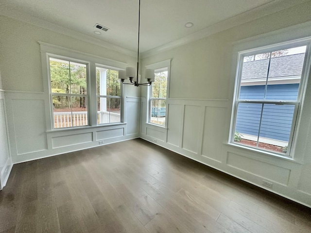 unfurnished dining area with wood-type flooring, ornamental molding, and a notable chandelier