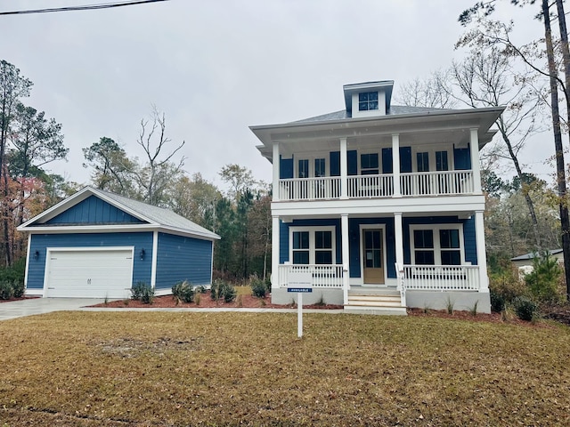 view of front facade with a porch, a garage, a balcony, and a front yard