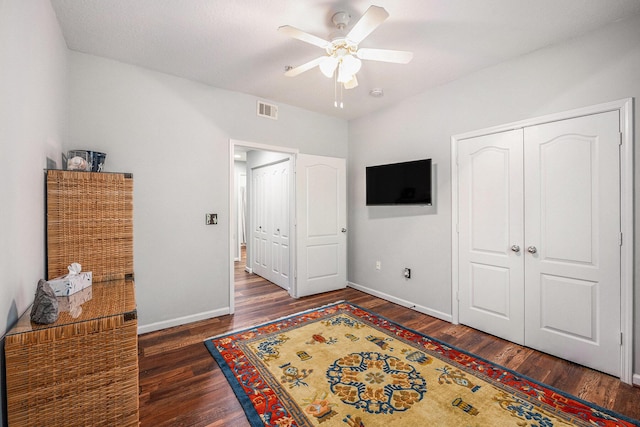 bedroom featuring ceiling fan, a closet, and dark wood-type flooring