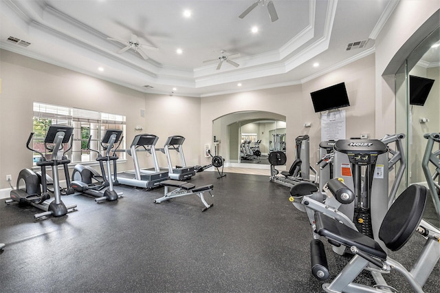 gym with a raised ceiling, ceiling fan, and ornamental molding