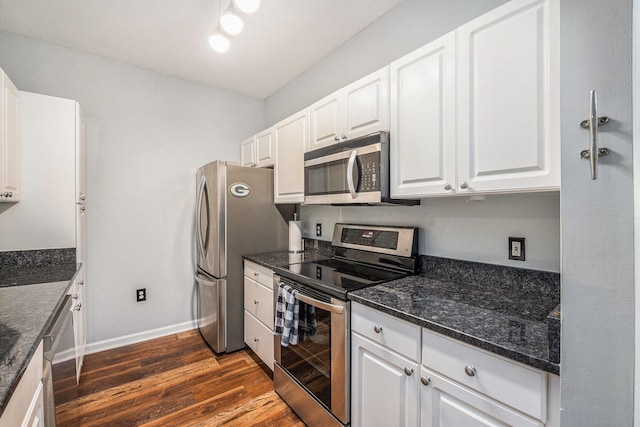 kitchen with dark stone counters, dark wood-type flooring, white cabinets, and stainless steel appliances