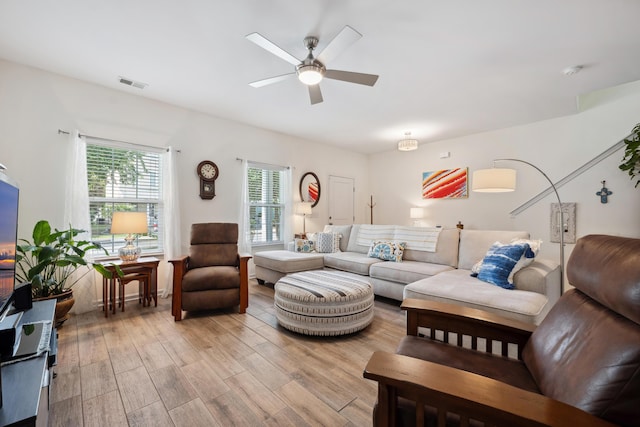 living area featuring a ceiling fan and light wood finished floors