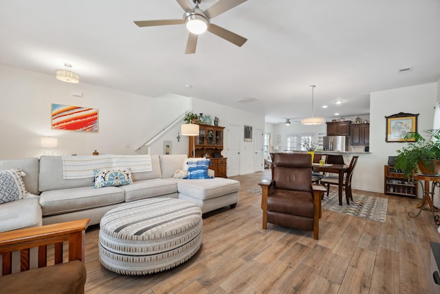 living area with ceiling fan, light wood-style floors, stairs, and recessed lighting