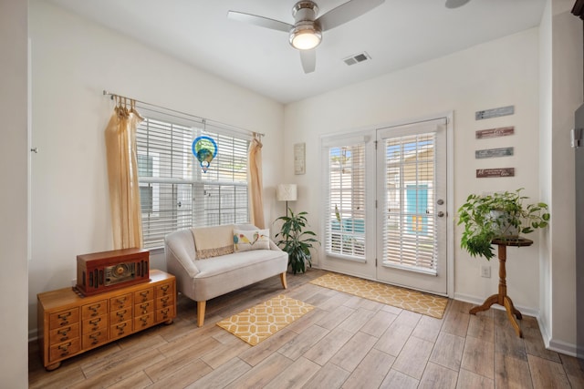 sitting room featuring wood finished floors, a ceiling fan, and baseboards