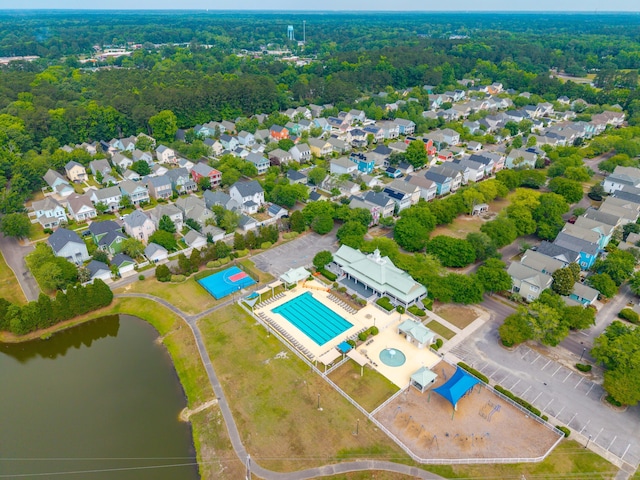 view of property location with a pool area, a nearby body of water, and nearby suburban area