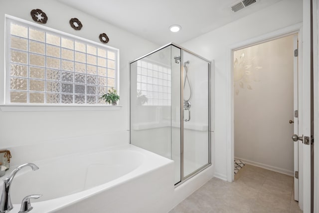 full bathroom featuring a stall shower, a bath, and tile patterned floors