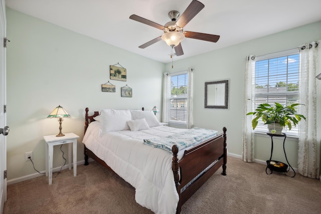 bedroom with light carpet, baseboards, and a ceiling fan