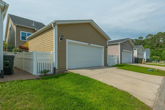 view of side of property with a garage, an outdoor structure, and driveway