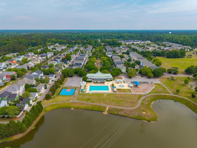 aerial overview of property's location with a pool, a large body of water, and nearby suburban area