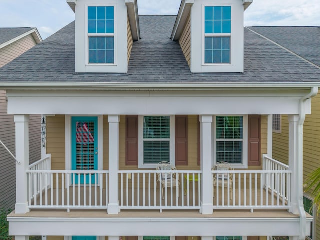view of front of home with a shingled roof and covered porch