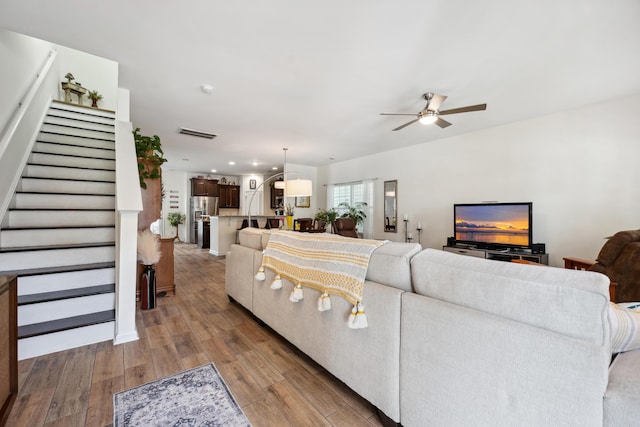living area featuring stairs, wood finished floors, ceiling fan, and recessed lighting