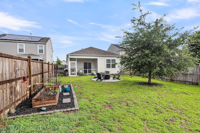 9712 Fanning Basket Ln, Ladson, SC 29456 - back of property featuring a vegetable garden, an outdoor fire pit, and a sunroom