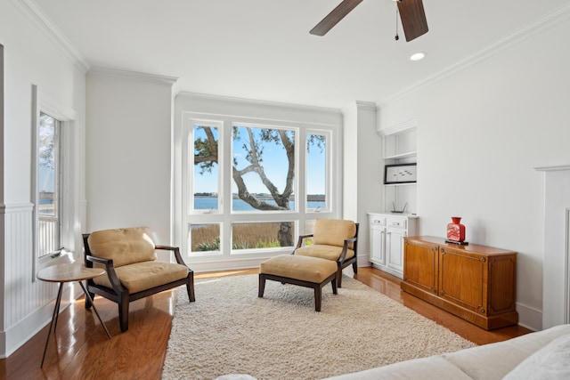 sitting room with a water view, crown molding, and a wealth of natural light