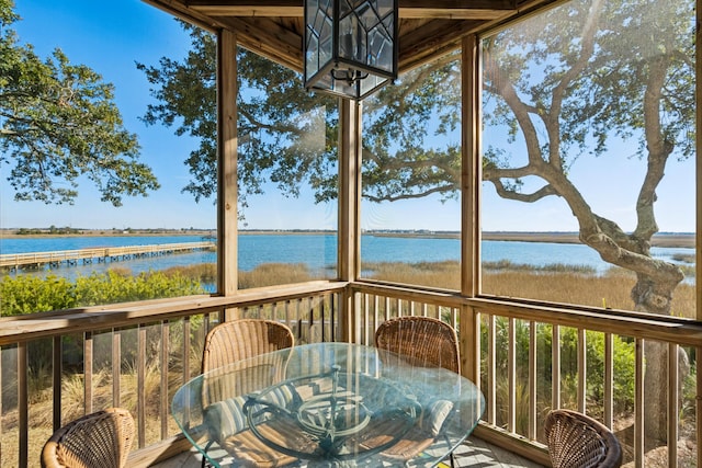 sunroom featuring a wealth of natural light and a water view