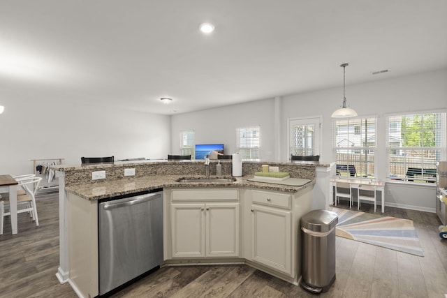 kitchen featuring stainless steel dishwasher, decorative light fixtures, dark wood finished floors, and a sink
