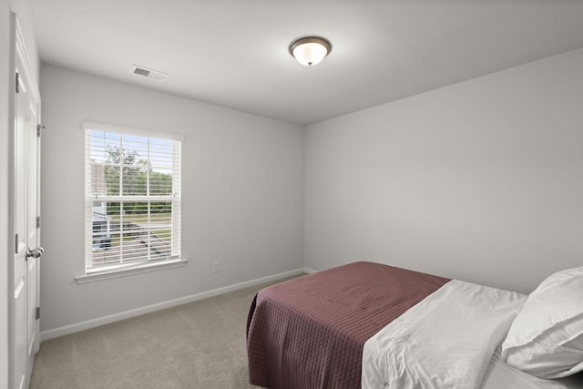 bedroom with light colored carpet, baseboards, and visible vents