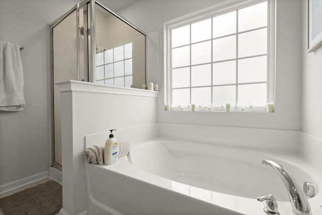 bathroom featuring a bath and a stall shower