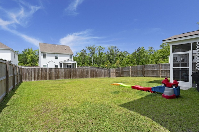 view of yard with a fenced backyard and a sunroom