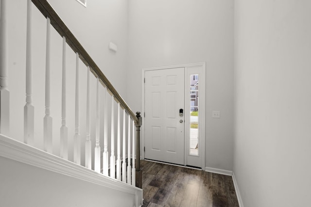 foyer with a high ceiling, baseboards, wood finished floors, and stairway