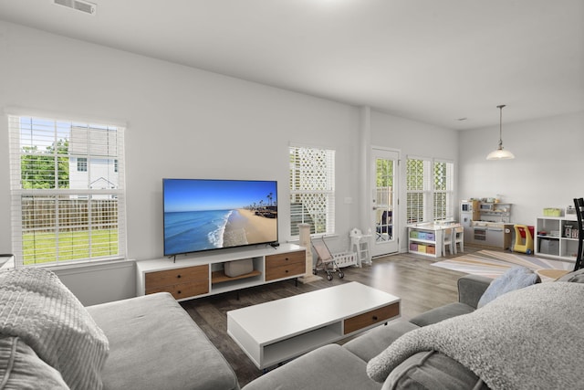 living area with visible vents and wood finished floors