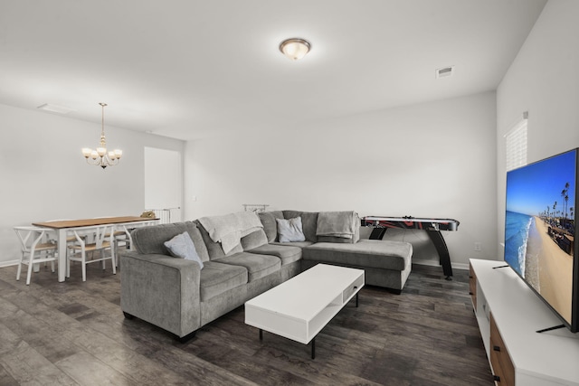 living area with baseboards, an inviting chandelier, dark wood-style floors, and visible vents