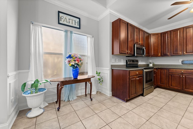 kitchen featuring ceiling fan, light tile patterned floors, stainless steel appliances, and ornamental molding