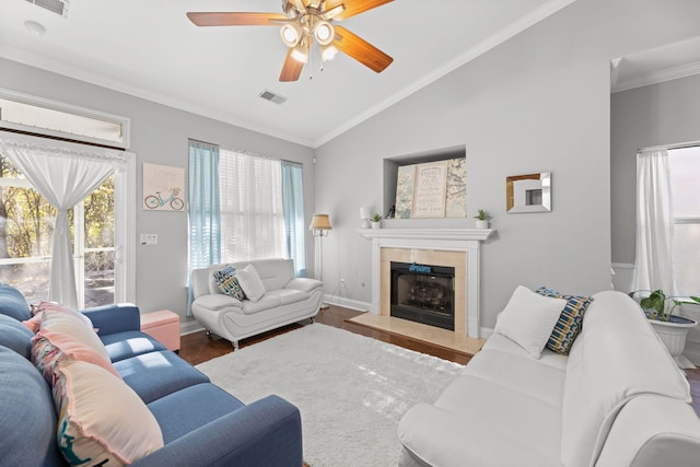 living room with a tile fireplace, a healthy amount of sunlight, hardwood / wood-style flooring, and lofted ceiling