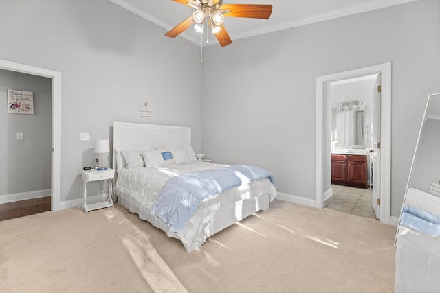 carpeted bedroom featuring ensuite bath, crown molding, and ceiling fan