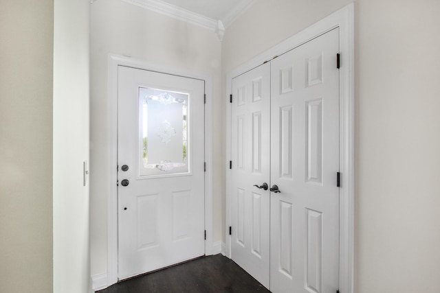 foyer entrance featuring dark wood finished floors, crown molding, and baseboards