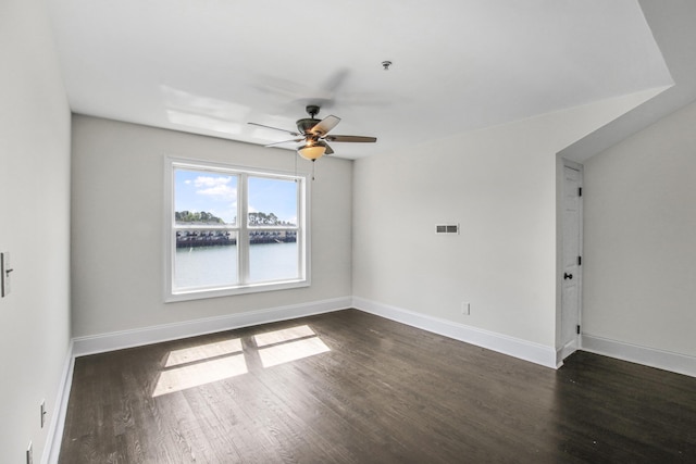 unfurnished room featuring baseboards, a ceiling fan, visible vents, and dark wood-style floors