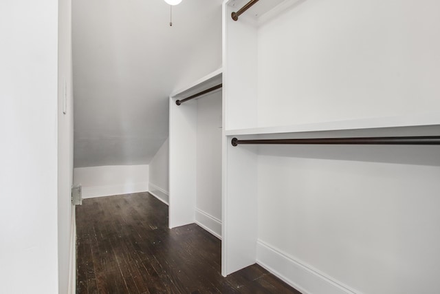 spacious closet with dark wood-type flooring and lofted ceiling