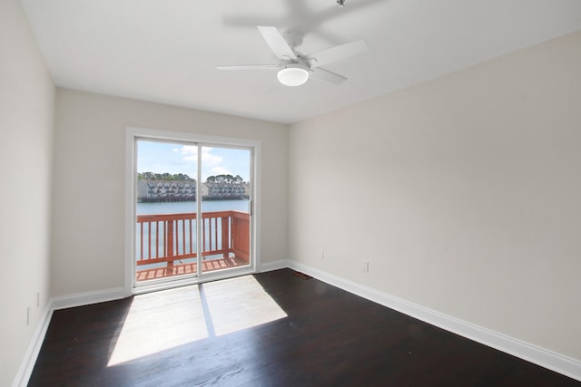 unfurnished room with baseboards, ceiling fan, and dark wood-style flooring