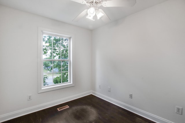 unfurnished room with dark wood-type flooring, visible vents, baseboards, and ceiling fan