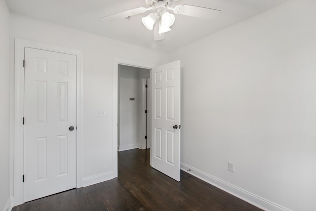 unfurnished bedroom featuring a ceiling fan, baseboards, and dark wood-type flooring