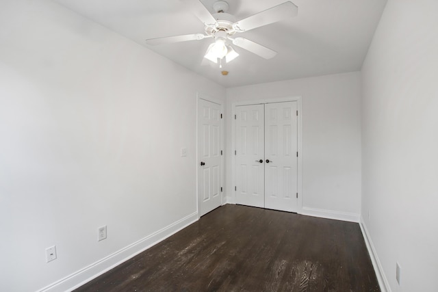 unfurnished bedroom with a closet, a ceiling fan, baseboards, and dark wood-style floors