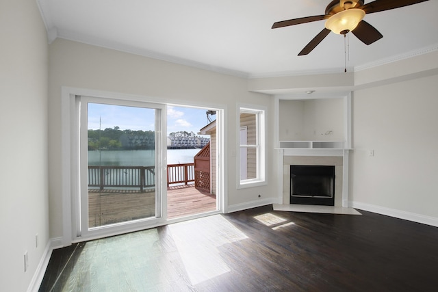 unfurnished living room featuring crown molding, a fireplace with flush hearth, baseboards, and dark wood finished floors