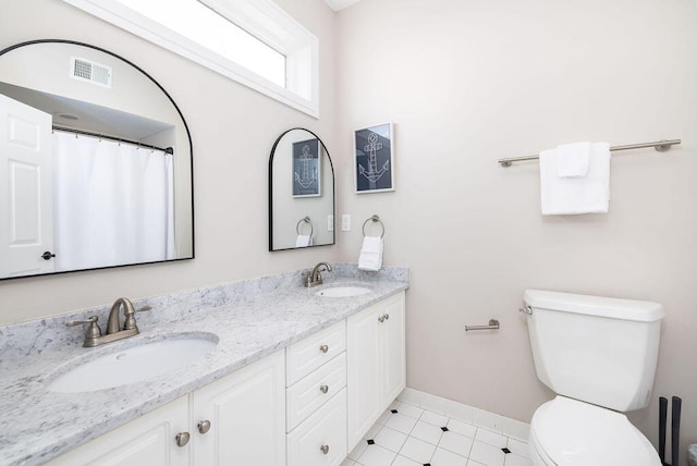 full bath featuring a sink, visible vents, toilet, and double vanity