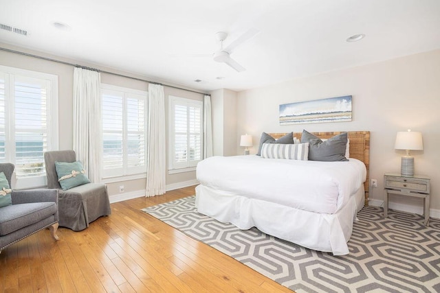 bedroom with visible vents, multiple windows, baseboards, and hardwood / wood-style floors