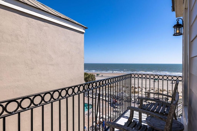 balcony featuring a beach view and a water view